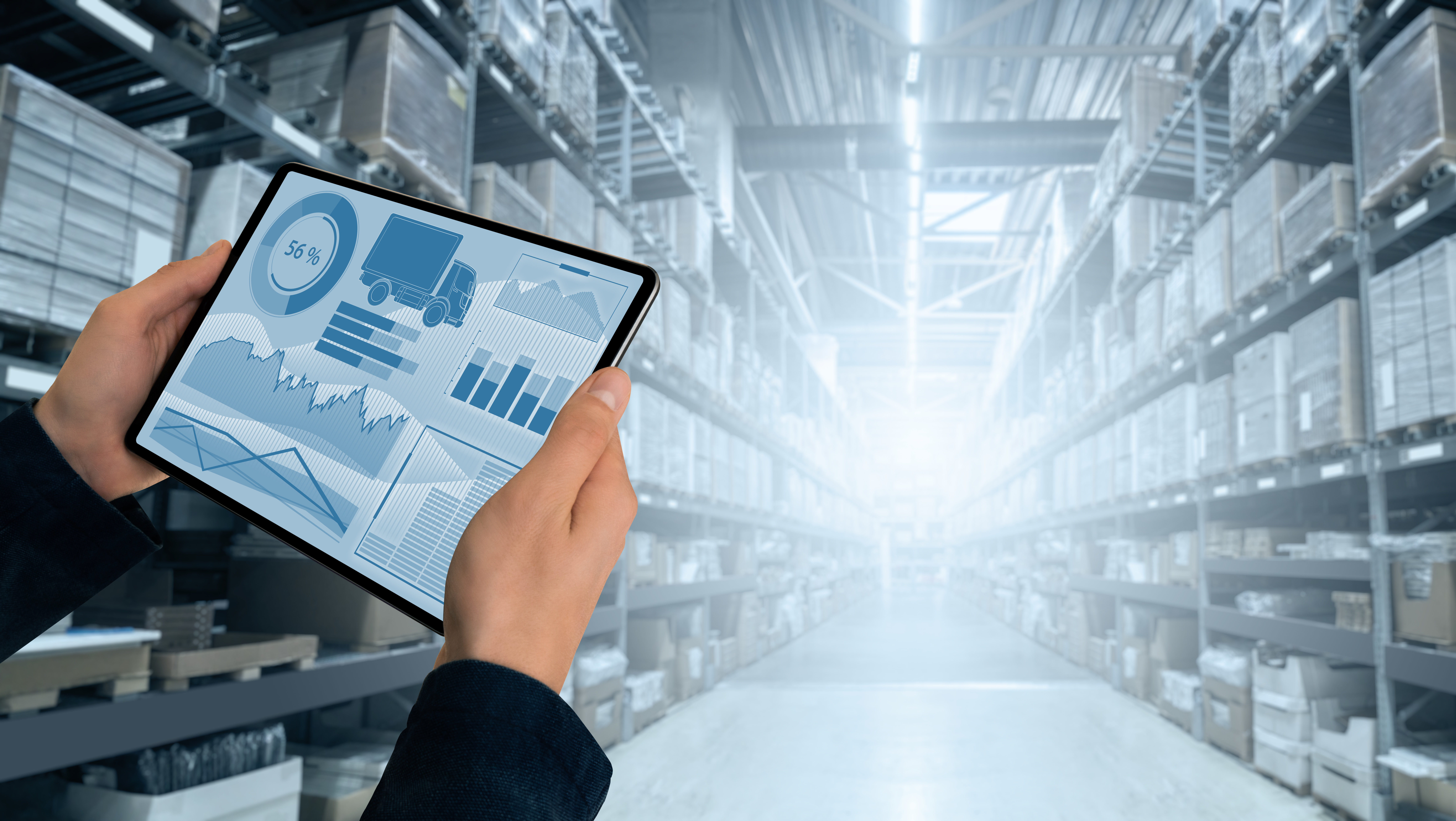 Logistics Featured Image - Warehouse with hands holding a tablet.